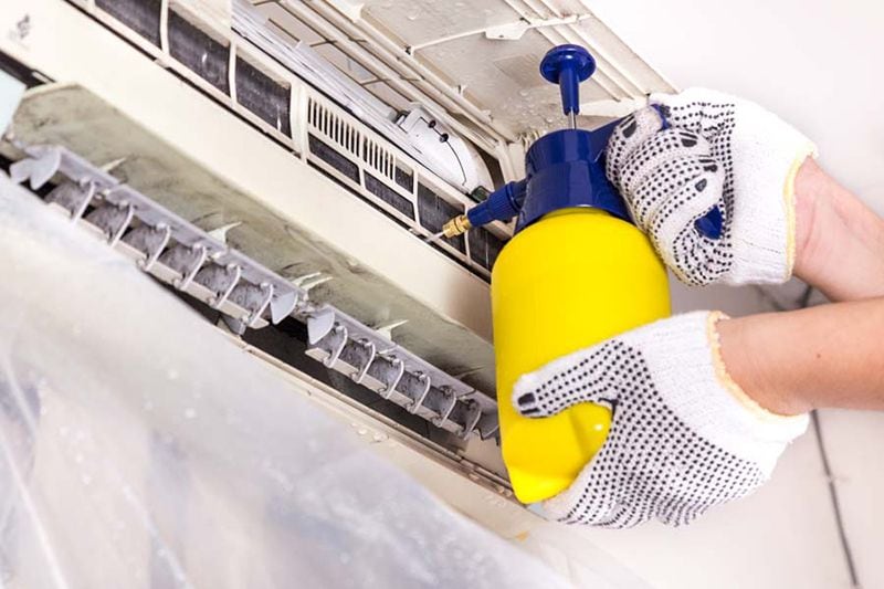 AC Maintenance Checklist. Image shows an HVAC professional servicing a ductless mini split.